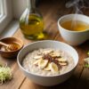 Dieta przy zapaleniu żołądka — owsianka z bananem, napar ziołowy i kiełki brokułu na drewnianym stole